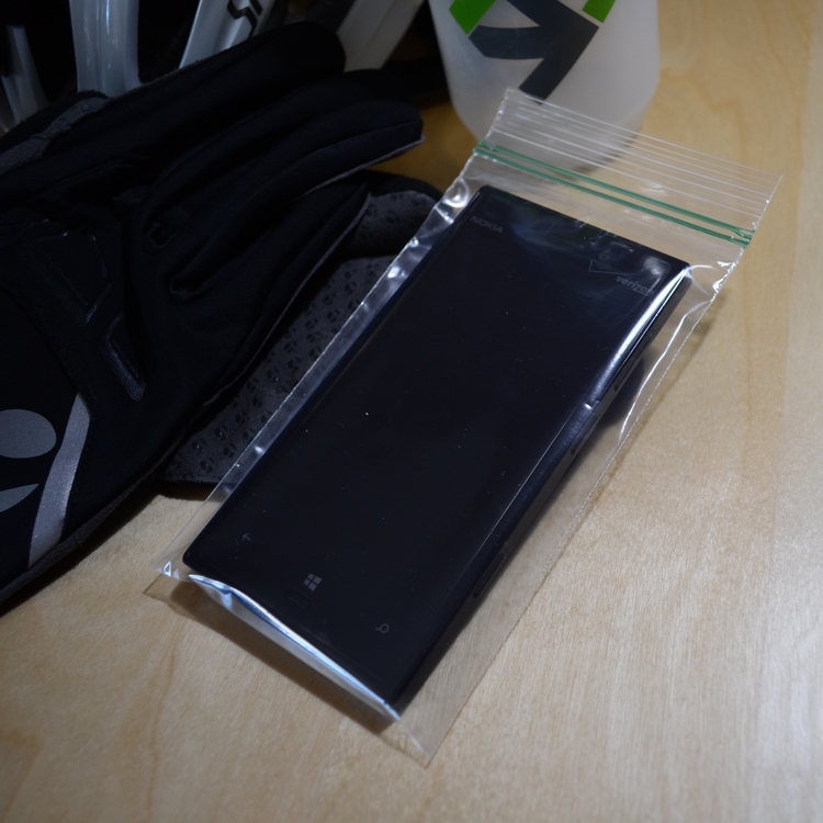 Front view of a smartphone inside a small zipper-closure bag